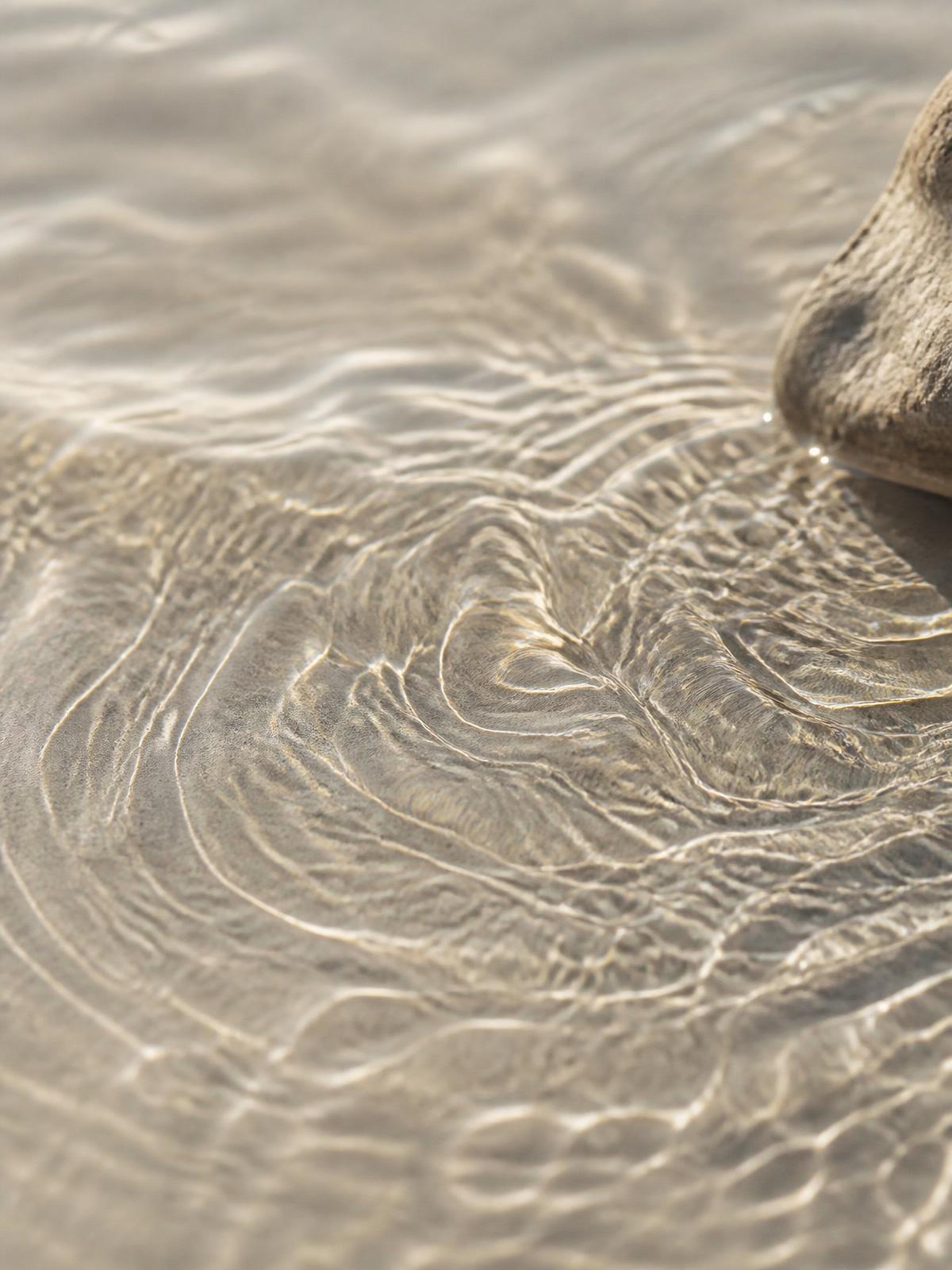 Macro shot of clean water rippling with soft light reflections